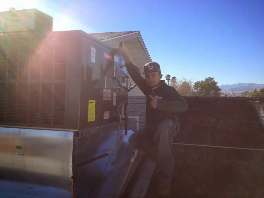 HVAC technician performing Air Duct Cleaning on a rooftop unit in North Platte